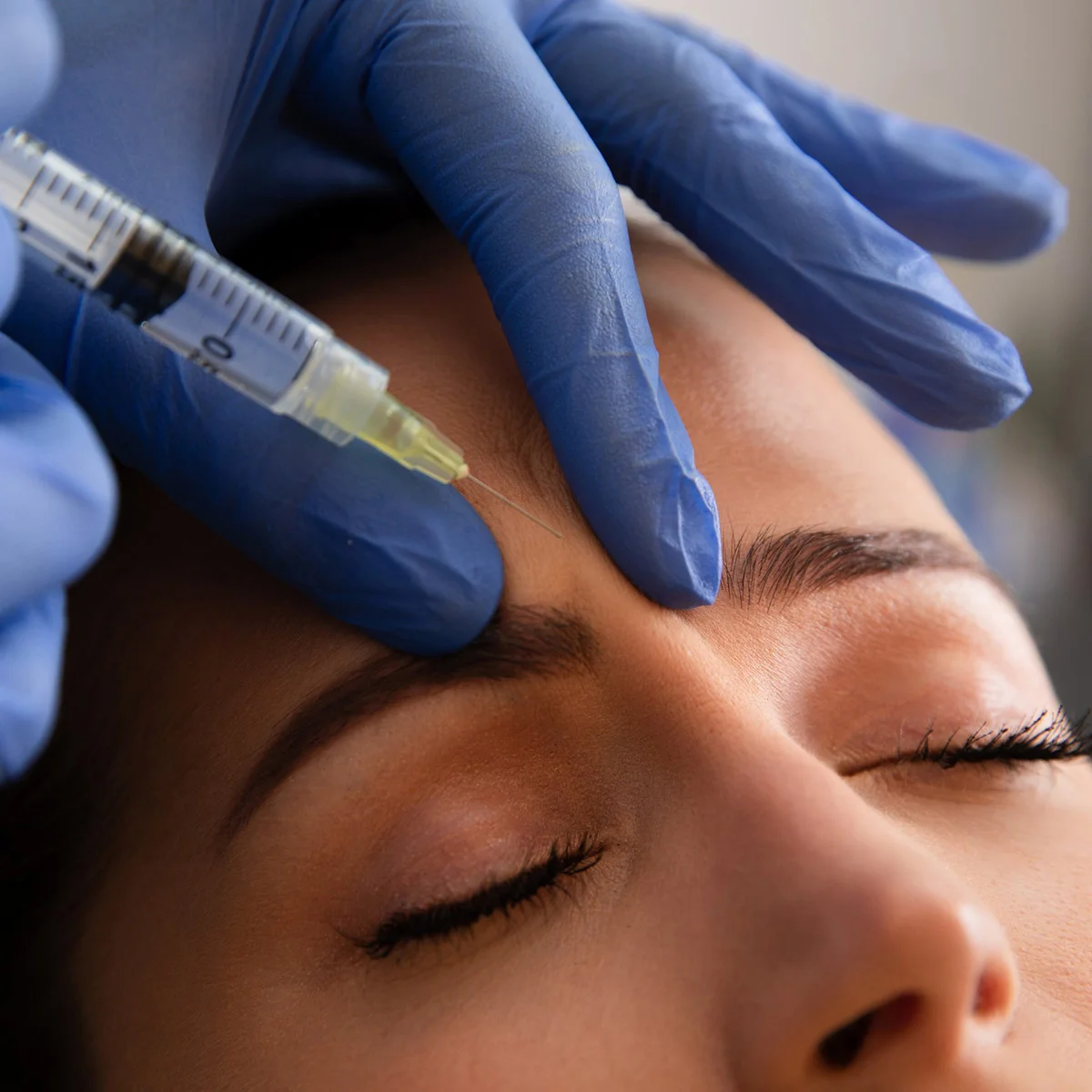 Close up woman getting BOTOX injections to her forehead and browline