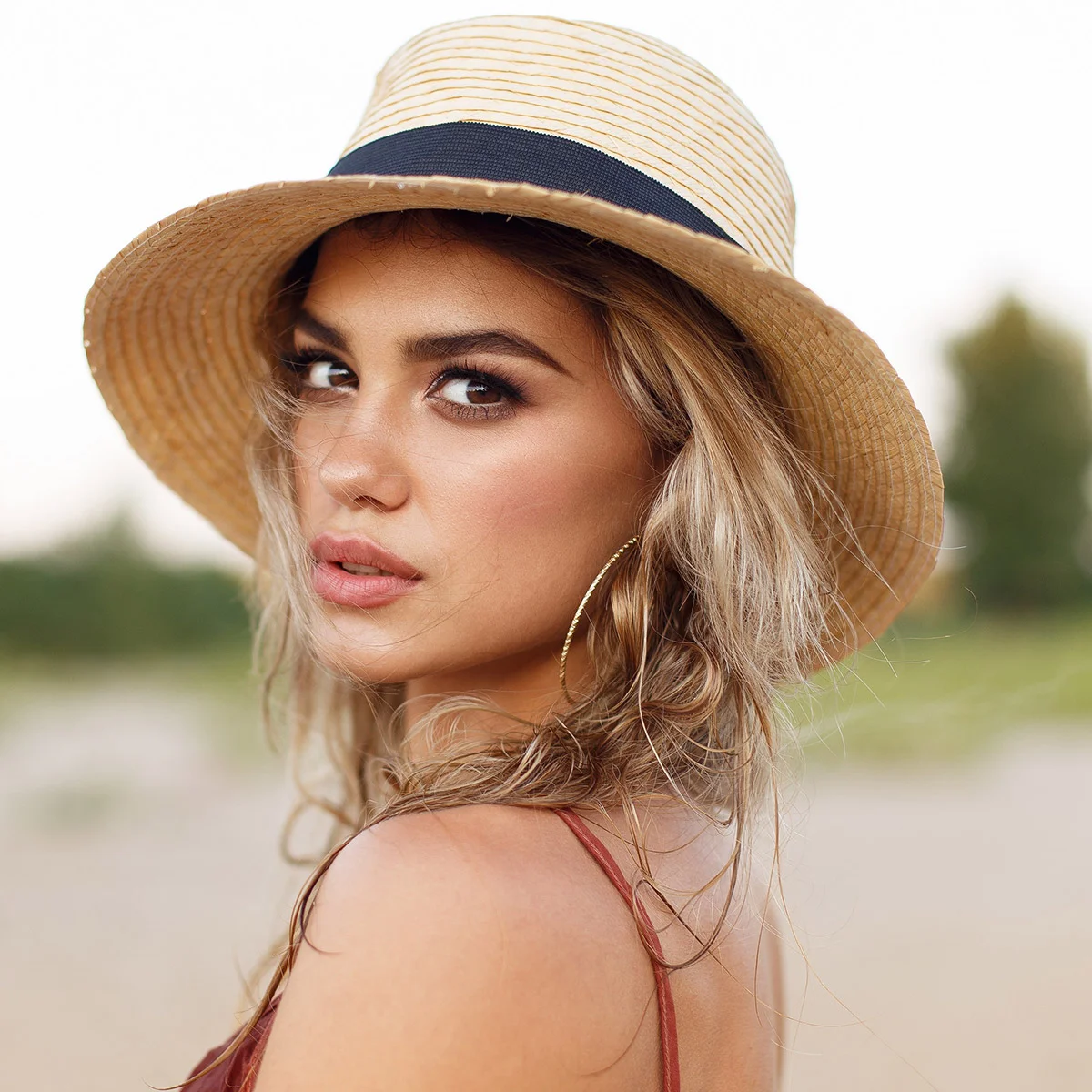 Woman with a sun hat looking back over her shoulder